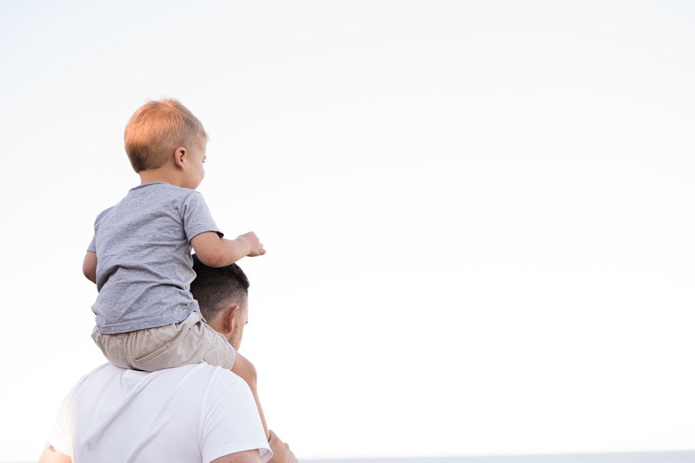 Father carrying his child on his shoulders outdoors
